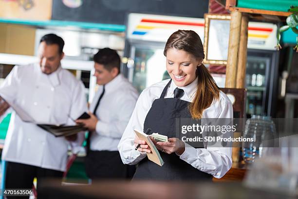 friendly waitress in tex-mex restaurant counting tips after shift - gratuity stock pictures, royalty-free photos & images