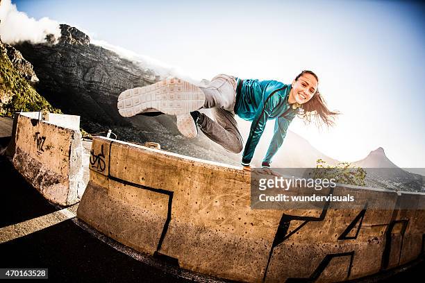 teen breakdance mädchen, die ein parkour- springen über eine wand - girl jumping stock-fotos und bilder
