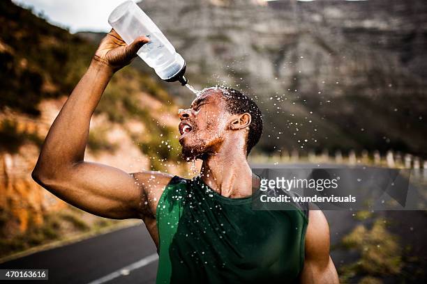 afrikanische amerikanische sportler planschen wasser im gesicht nach excer - mann wasser trinken sport stock-fotos und bilder