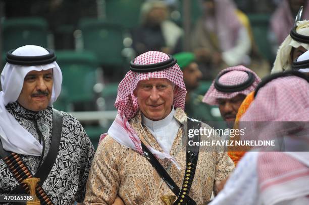 Britain's Prince Charles wears traditional Saudi uniform as he dances with Saudi Tourism minister Salman bin Sultan during the traditional Saudi...