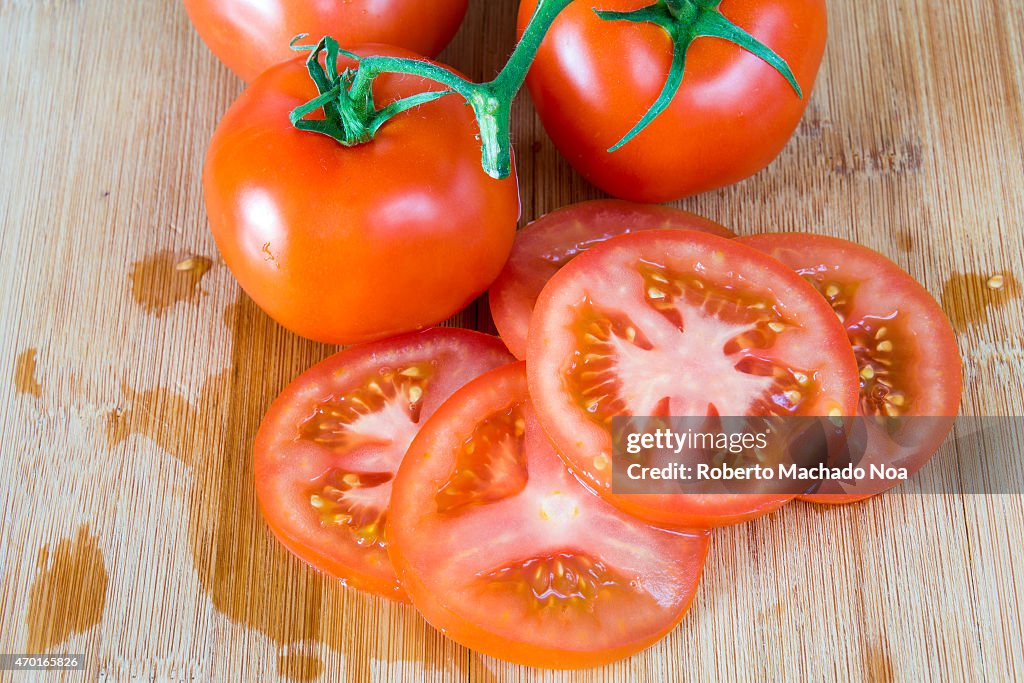 Red ripe tomatoes over a wooden cutting board,a more...