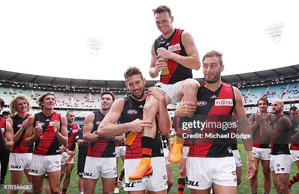 Brendon Goddard of the Bombers is carried off after winning his 250th game by Cale Hooker and Tom Bellchambers during the round three AFL match...