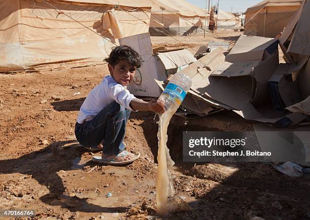 Syrian girl play in dirty water need the collapsed latrine at the Zaatari Refugee Camp in Jordan.