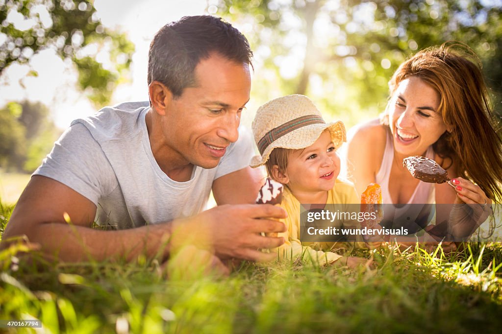 Junge Familie zusammen Essen Eis in einem park