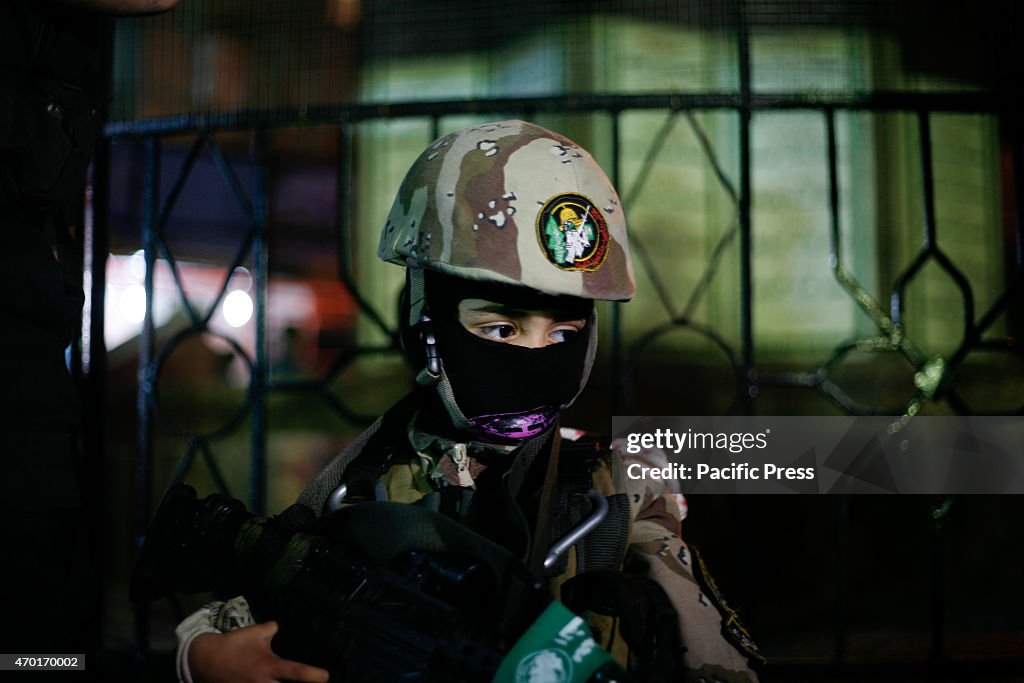 Palestinian members of al-Qassam Brigades stand near a model...