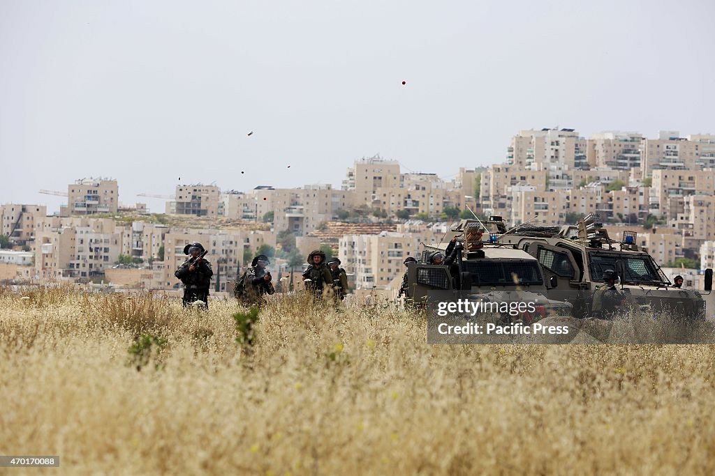 Israeli soldiers launch tear gas bombs into protesters in...