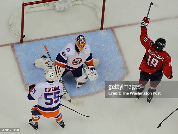 Washington Capitals center Nicklas Backstrom raises his stick as he skates past New York Islanders goalie Jaroslav Halak after scoring during the...