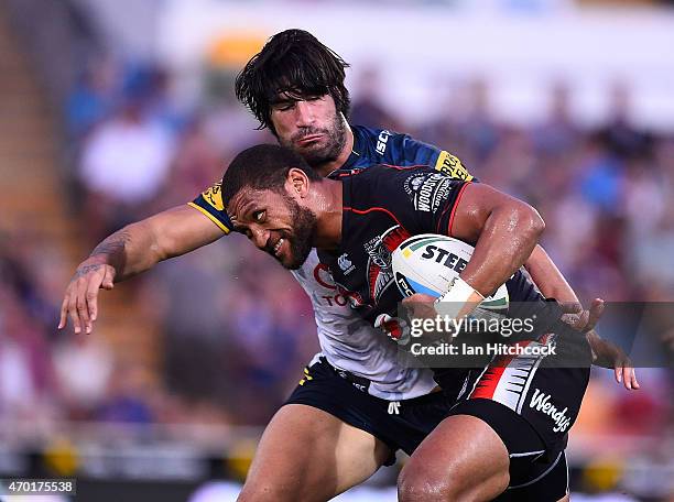 Manu Vatuvei of the Warriors is tackled by James Tamou of the Cowboys during the round seven NRL match between the North Queensland Cowboys and the...