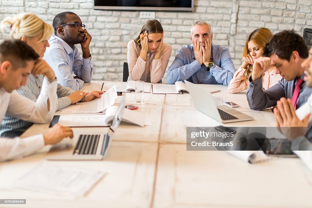 Large group of worried business people having a meeting.