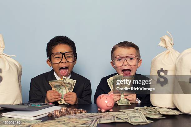 giovane business bambini fare facce con un sacco di soldi - making money foto e immagini stock