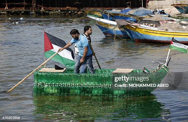 Palestinian Baha Obeid and his cousin Mohamed Obeid paddle on their makeshift boat made of plastic bottles on April 18, 2015 at the port of Gaza...