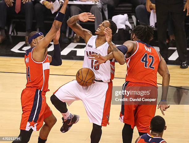 DeMar DeRozan of the Toronto Raptors is fouled by Nene Hilario of the Washington Wizards during the game between the Toronto Raptors and the...