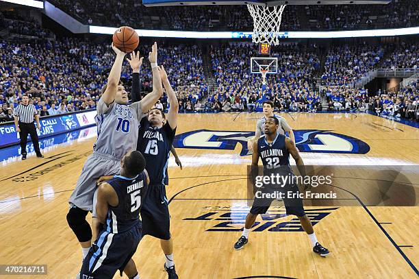 Grant Gibbs of the Creighton Bluejays finishes a shot over Ryan Arcidiacono and Tony Chennault of the Villanova Wildcats during their game at...