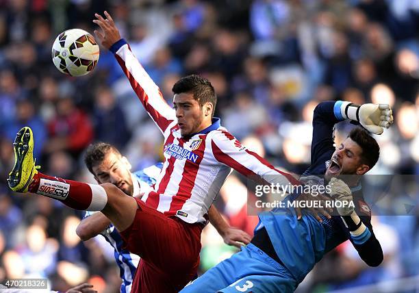 Atletico Madrid's Mexican forward Raul Jimenez jumps for the ball with Deportivo's goalkeeper Fabri and defender Alberto Lopo during the Spanish...