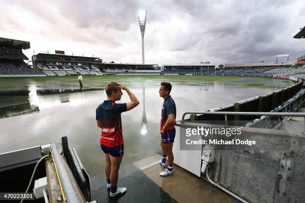 Bulldogs players Lachie Hunter and Luke Dahlhaus look at the ground that is under water after a storm passed through before the round two AFL NAB...