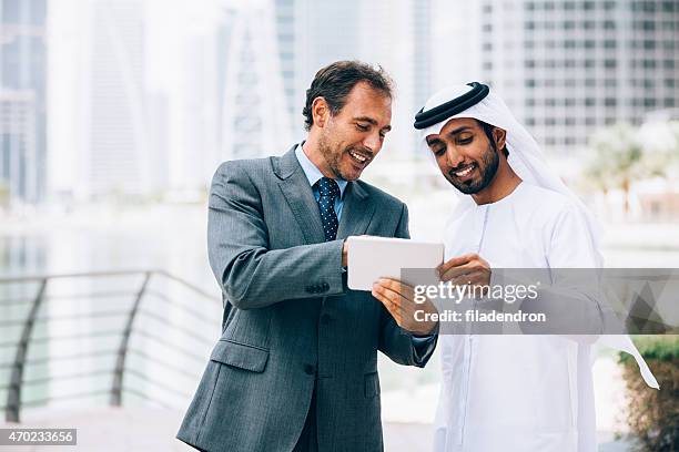 businessmen in dubai making business - dubai marina stock pictures, royalty-free photos & images