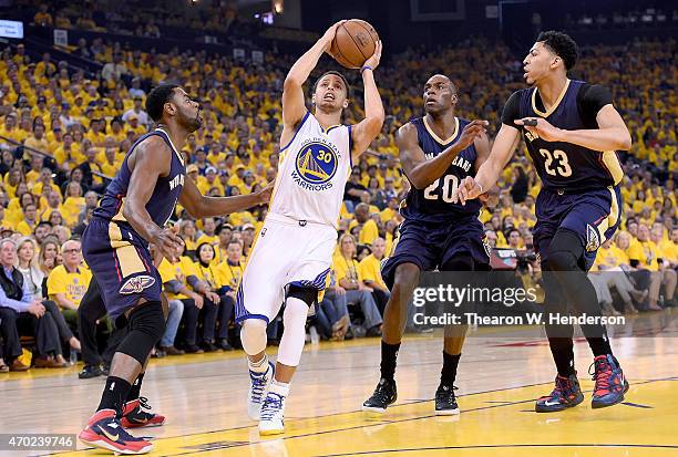 Stephen Curry of the Golden State Warriors drive on Anthony Davis, Tyreke Evans and Quincy Pondexter of the New Orleans Pelicans in the first quarter...