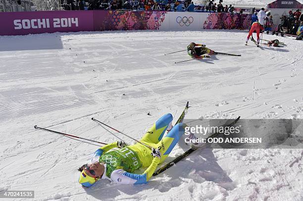 Slovenia's Katja Visnar lies on the snow after crossing the finish line in the Women's Cross-Country Skiing Team Sprint Classic Semifinals at the...