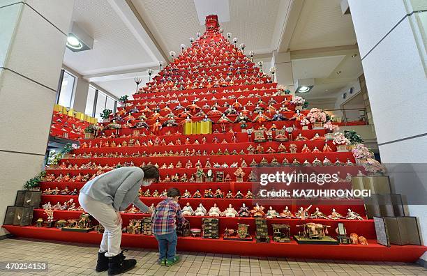 Boy and his mother look at Japanese ornamental dolls displayed on a seven-meter-high pyramid with over 1,800 hina dolls for the Konosu Bikkuri...