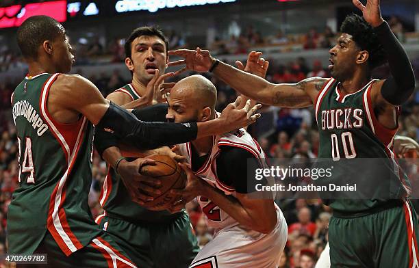 Taj Gibson of the Chicago Bulls is pressured by Giannis Antetokounmpo, Zaza Pachulia and O.J. Mayo of the Milwaukee Bucks during the first round of...