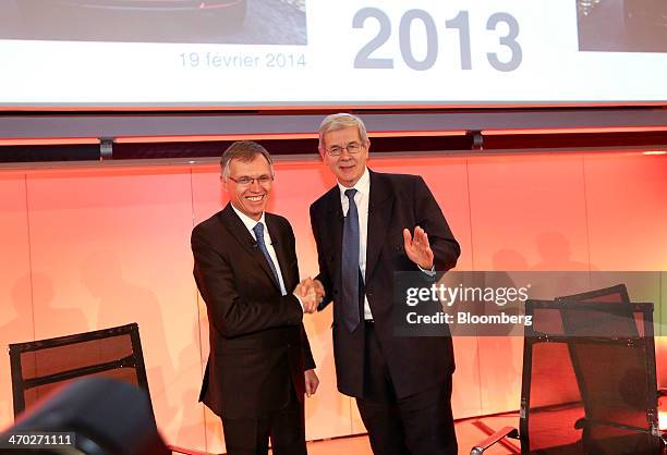 Carlos Tavares, incoming chief executive officer of PSA Peugeot Citroen, left, shakes hands with Philippe Varin, outgoing chief executive officer of...