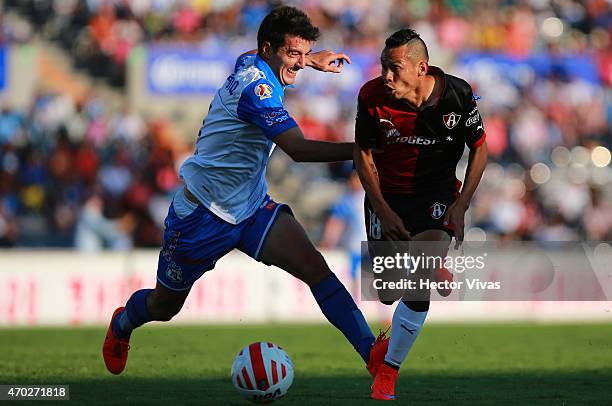 Juan de Dios Hernandez of Atlas struggles for the ball with Facundo Erpen of Puebla during a match between Puebla and Atlas as part of 14th round...
