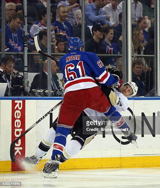 Rick Nash of the New York Rangers checks Ben Lovejoy of the Pittsburgh Penguins during the first period in Game One of the Eastern Conference...