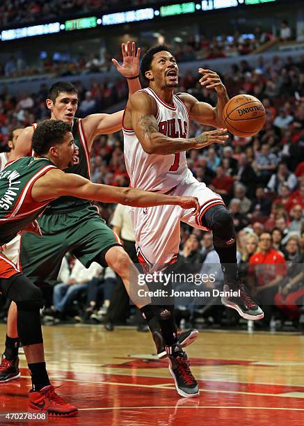 Michael Carter-Williams of the Milwaukee Bucks knocks the ball away from Derrick Rose of the Chicago Bulls after he had driven past Ersan Ilyasova...