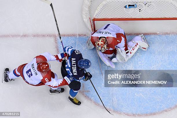 Finland's Juhamatti Aaltonen scores against Russia's goalkeeper Semyon Varlamov and Russia's Nikita Nikitin during the Men's Ice Hockey Quarterfinals...