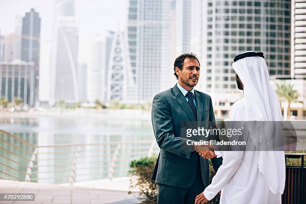businessmen in dubai handshake - international day two stock pictures, royalty-free photos & images