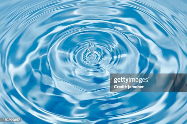 gota de agua sobre fondo azul - ondulado descrição física imagens e fotografias de stock