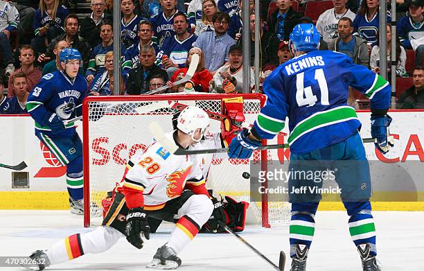 Ronalds Kenins of the Vancouver Canucks shoots the puck past Jonas Hiller of the Calgary Flames for his first NHL playoff goal during Game Two of the...