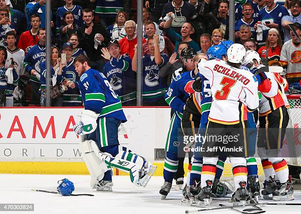 Eddie Lack of the Vancouver Canucks skates away as players with the Vancouver Canucks and the Calgary Flames mix it up during Game Two of the Western...