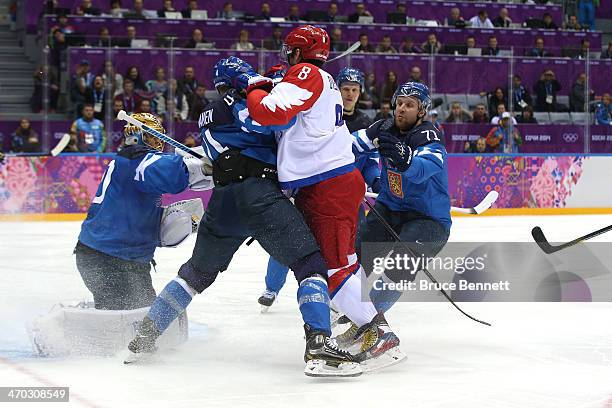 Alexander Ovechkin of Russia fights for position with Ossi Vaananen and Leo Komarov of Finland during the Men's Ice Hockey Quarterfinal Playoff on...