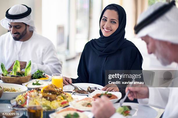 middle eastern woman eating with family - middle eastern food stockfoto's en -beelden