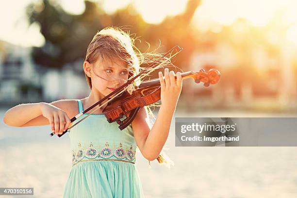 musik der sommer-mädchen spielt violine am strand - violine stock-fotos und bilder