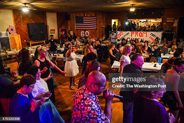 Maryann Frigge in white dress raising arms, dances at her high school prom-themed birthday party on Saturday, March 21 in Orting, WA. "I'm turning 60...