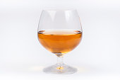 Half full glass of mead sitting on a white background