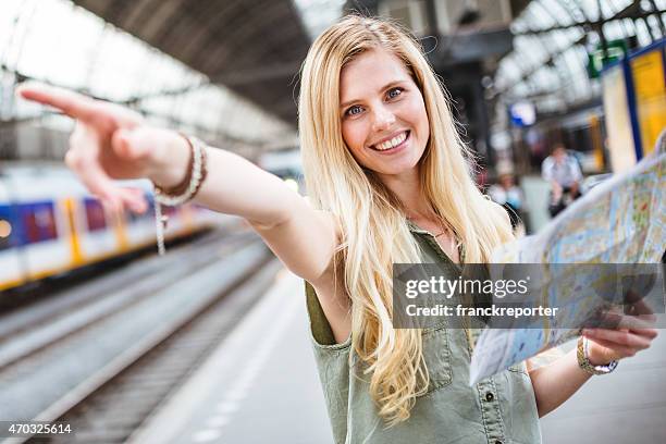 tourist in amsterdam looking map of the city - tourist information stock pictures, royalty-free photos & images