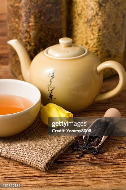 Tulip bloom next to oriental tea set on jute cloth