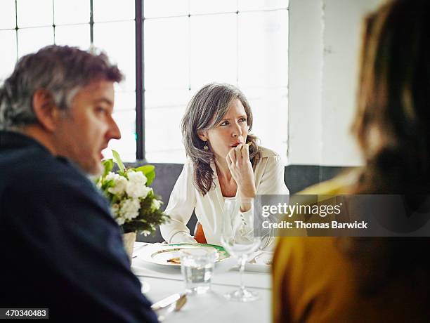 Woman sitting with friends at dinner party