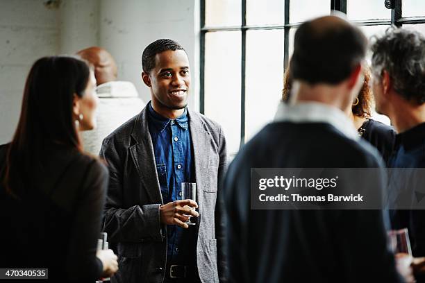 smiling man talking with friends at dinner party - shared prosperity stock pictures, royalty-free photos & images