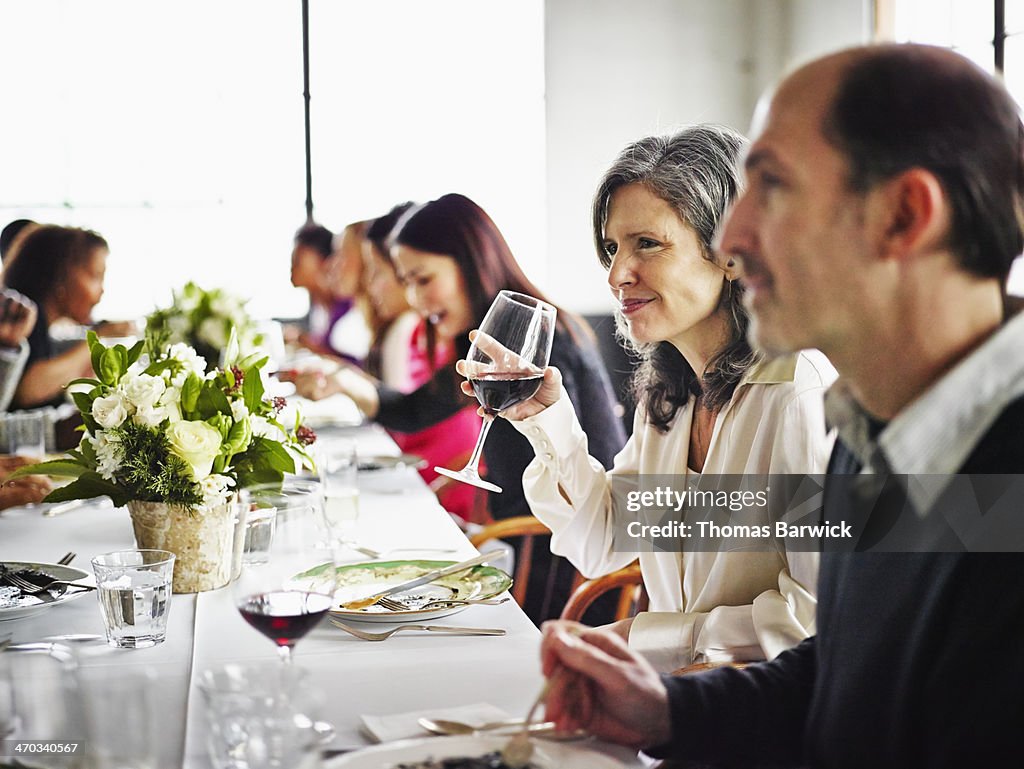 Woman drinking wine with friends at party