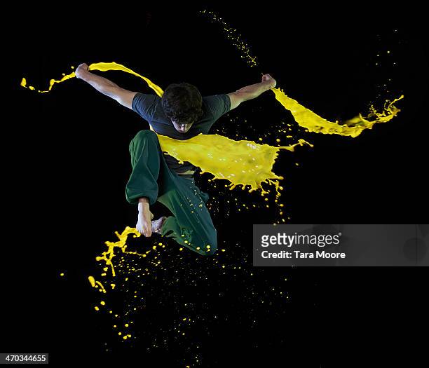 man jumping with paint splashes - paint mid air stock pictures, royalty-free photos & images