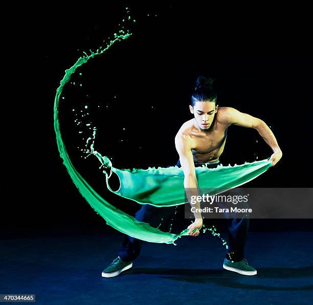 man dancing with green paint splashes - man splashed with colour fotografías e imágenes de stock