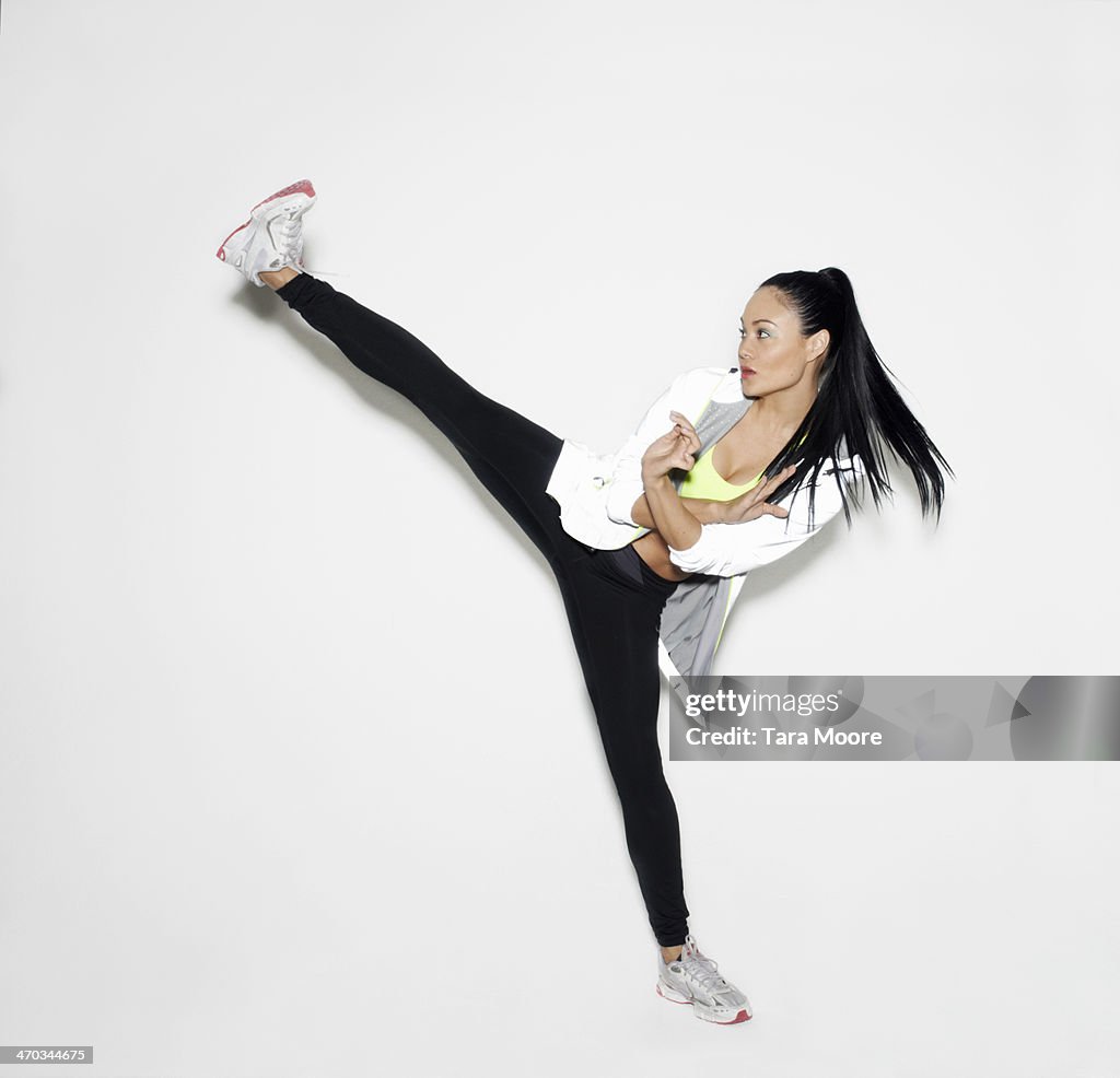 Sports woman doing karate kick