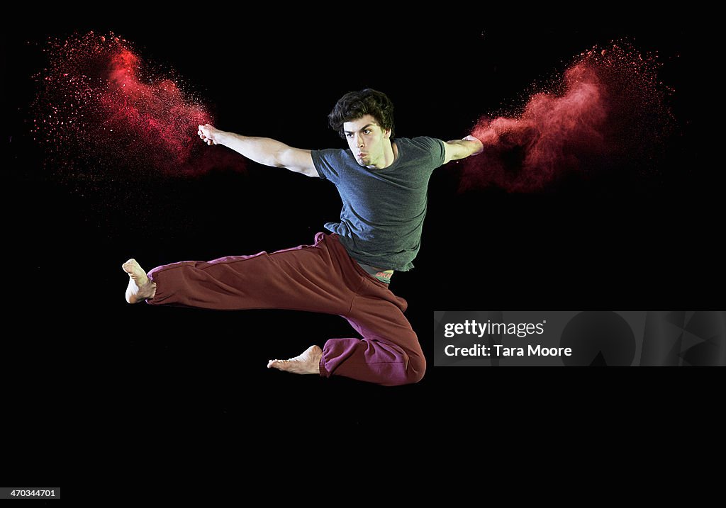 Man doing karate kick with red smoke