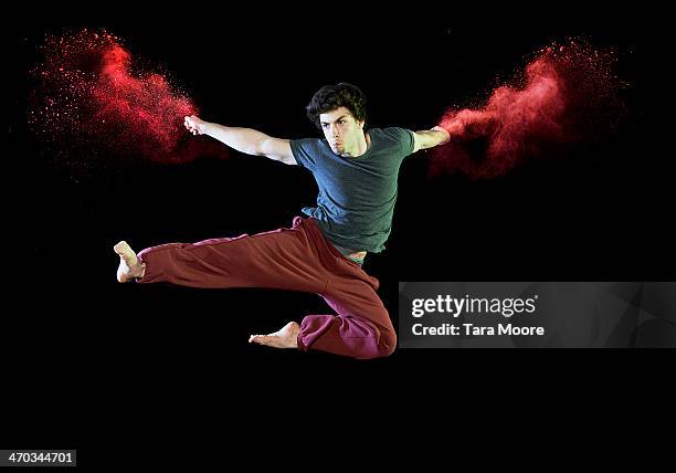 man doing karate kick with red smoke - distress flare stock pictures, royalty-free photos & images