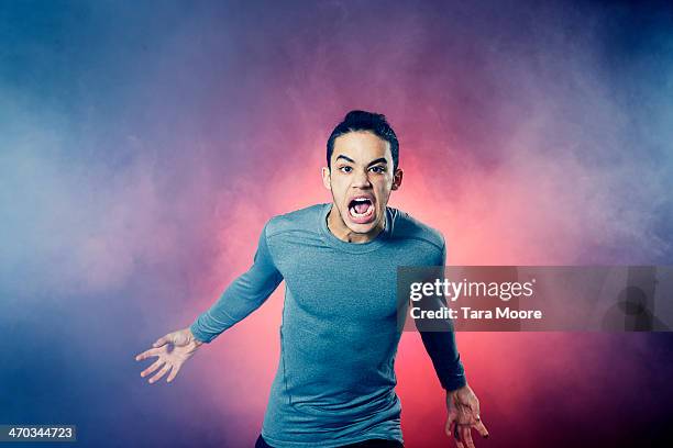 angry sports man running through smoke - aanvallen sporten stockfoto's en -beelden