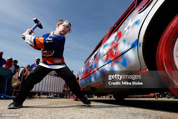 Islander fans participate in hitting the Smash Car prior to the game between the New York Islanders and the Washington Capitals the during Game Three...